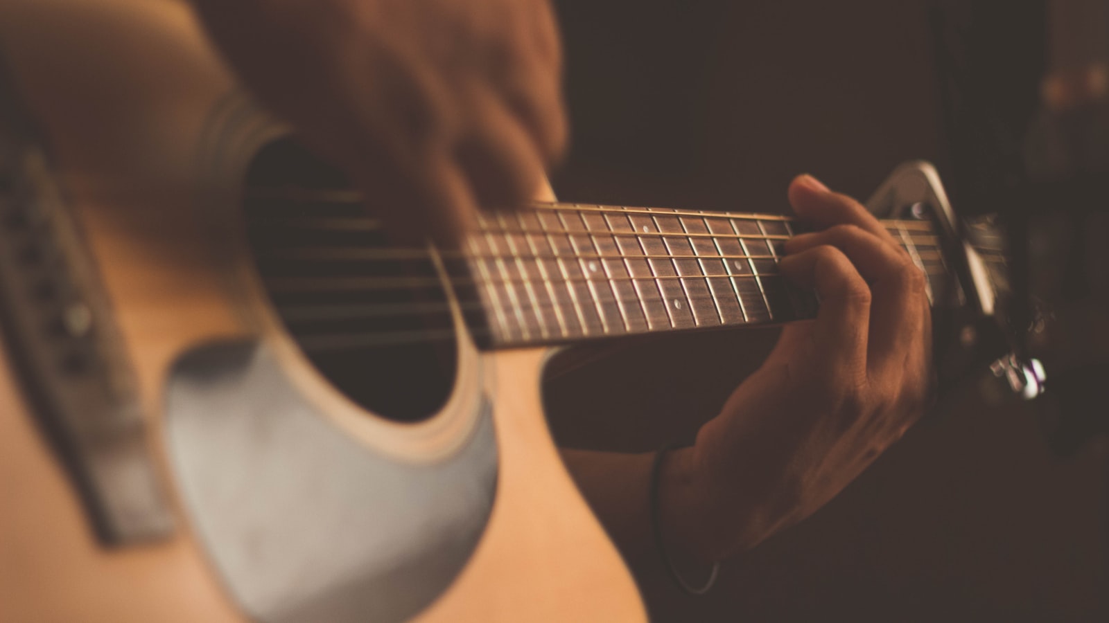 An acoustic guitar resting on a chair in soft natural light.